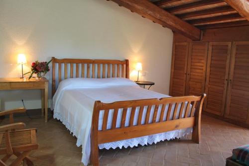 阿梅利亞的住宿－Agriturismo Poggio Della Rosa，一间卧室配有一张木床、一张桌子和一张书桌