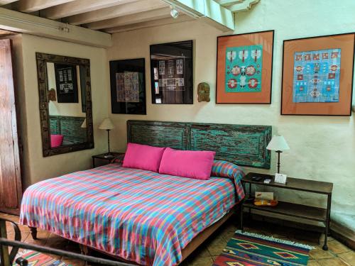 a bedroom with a bed with pink pillows at Hotel Casa Encantada in Pátzcuaro