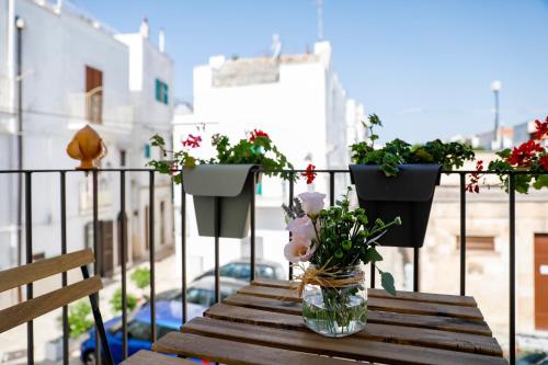 a vase of flowers on a table on a balcony at Dimora Pozzo Epifani in Noci