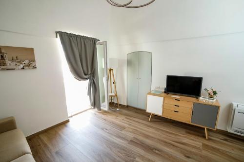 a living room with a television on a wooden dresser at Dimora Pozzo Epifani in Noci