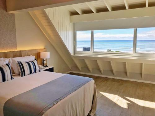 a bedroom with a bed with a view of the ocean at Almarena Apart & Hotel Boutique in Costa del Este