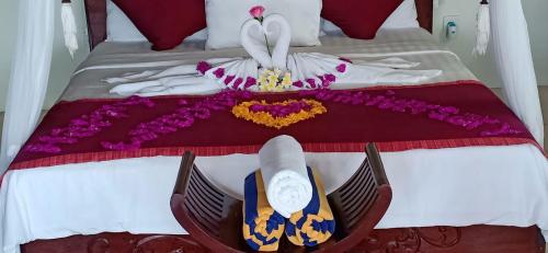 a bed with a dress and a clock on it at Bali Harmony Villa in Ubud