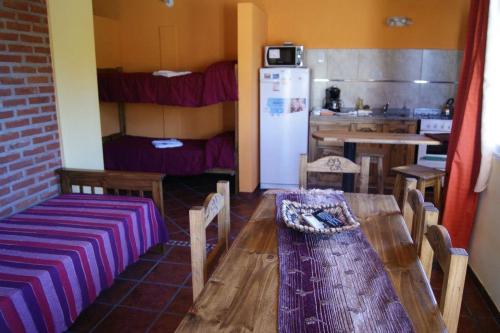 a room with a table and a kitchen with a refrigerator at Cabañas Peumayen in Colón