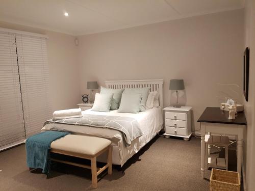 a bedroom with a white bed and a desk at Drome (Eng Dreams) in Gansbaai