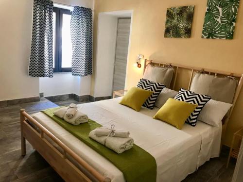 une chambre avec un grand lit avec des serviettes dessus dans l'établissement Domus Rubra, à Castelsardo