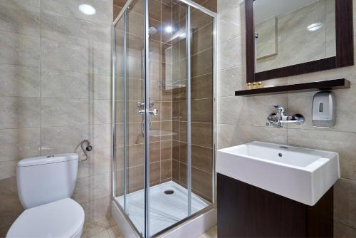 a bathroom with a shower and a toilet and a sink at Hotel Mużakowski in Łęknica