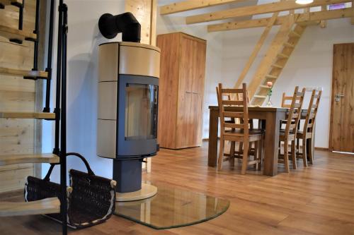 a fireplace in a living room with a table and chairs at Penzion Beskydkrby in Ostravice