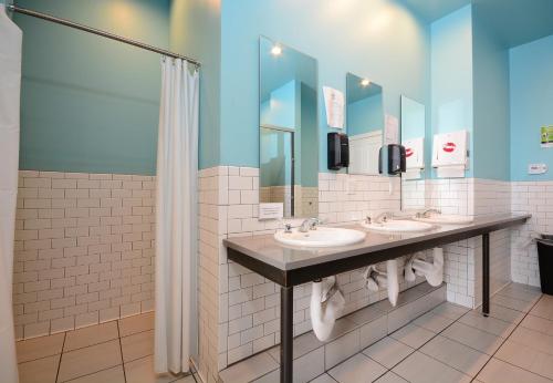 a bathroom with three sinks and a shower at Hostel Fish in Denver