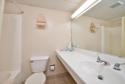 a bathroom with a toilet and a sink and a mirror at Sea Bay Hotel in Ocean City