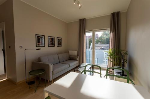 a living room with a couch and a table and chairs at Apartamenty Dobry Browar in Gniezno