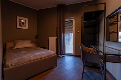 a bedroom with a bed and a table and a desk at Apartamenty Dobry Browar in Gniezno