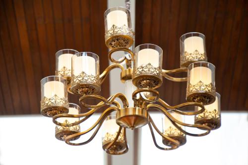 a gold chandelier with wine glasses on it at Islamabad Regalia Hotel in Islamabad