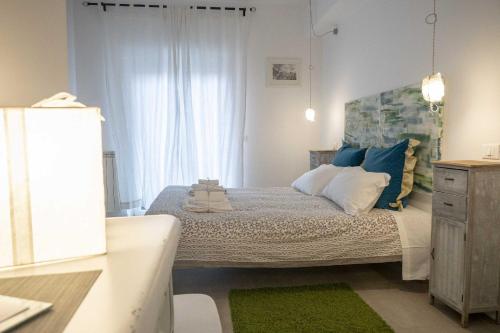 1 dormitorio con 1 cama con almohadas azules y blancas en Tempo Lento, en Roma