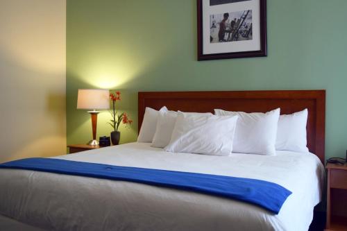 een slaapkamer met een groot bed en een blauwe deken bij UMass Lowell Inn and Conference Center in Lowell