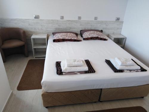 a bedroom with a large bed with white sheets and pillows at Guest House Harmony in Veliko Tŭrnovo
