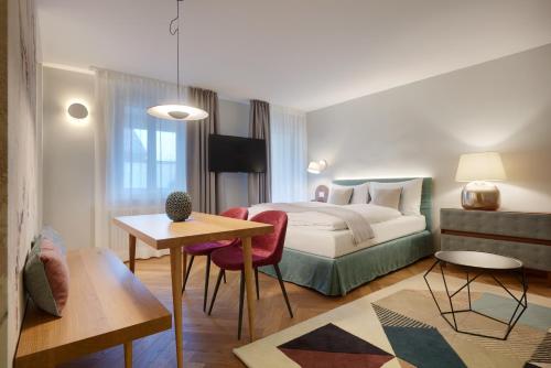 a hotel room with a bed and a table at Cityflair Boutique Apartments in Bolzano