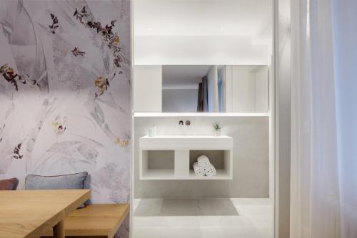 łazienka z białą umywalką i stołem w obiekcie Cityflair Boutique Apartments w mieście Bolzano