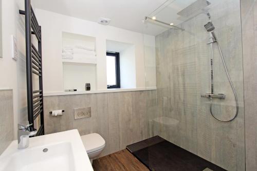 y baño con ducha, aseo y lavamanos. en Monkstadt No 6 -Jessie's Hideaway en Portree