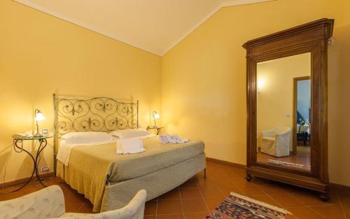 a bedroom with a bed and a large mirror at Cottage Castelletto in Sinalunga