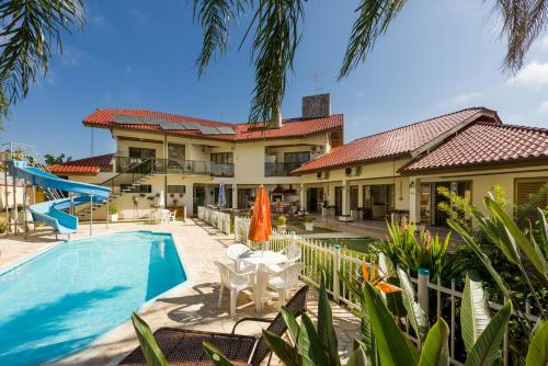a villa with a swimming pool and a house at Pousada Lozalti in Florianópolis