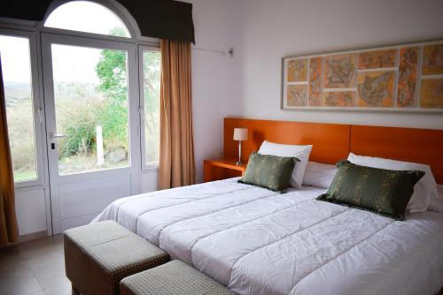 
a bedroom with a large bed and a large window at La Posada Del Qenti in Villa Carlos Paz
