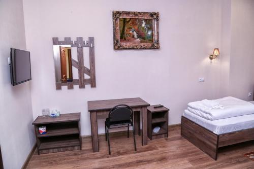 a bedroom with a desk and a bed and a mirror at Sofya in Goris