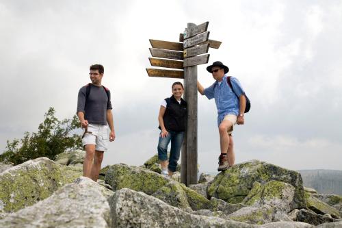 three people standing next to a sign on a mountain at Genusshotel "Zum Wendl" in Freyung