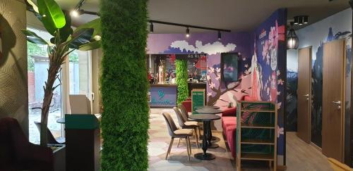 a restaurant with a bar with a green wall at Baobab Suites in Siófok