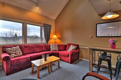 a living room with a red couch and a table at Cozy,1 bedroom loft condo! Ski back trails, shuttle& Sports center Highridge E11 in Killington