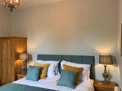 a bedroom with a bed with blue and yellow pillows at Hassop Station rooms on the Monsal Trail in Bakewell