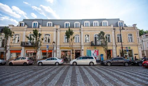 a large building with cars parked in front of it at Margi Boutique Hotel by DNT Group in Tbilisi City