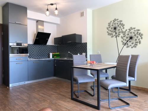 a kitchen with a table and chairs in a room at LuxApartament 1 - z widokiem i garażem w nowym Zeta Park in Ustroń