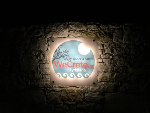 a sign for a weeding company on a stone wall at WeCrete Apartments in Drapaniás