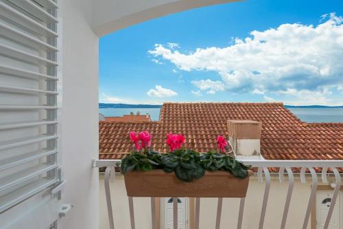 a balcony with a planter with pink flowers on it at Lavica Seaside Apartments, Podstrana in Podstrana