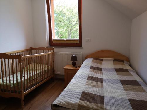 sypialnia z 2 łóżeczkami dziecięcymi i oknem w obiekcie Apartments Trebušak w mieście Laze v Tuhinju