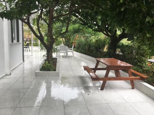 a wooden bench sitting on a sidewalk next to a tree at PASHA APART~BOUTİQUE HOTEL/YALOVA in Yalova