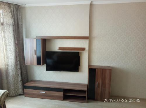 een entertainmentcentrum met een flatscreen-tv in een hotelkamer bij Люкс апартаменты на Позняках in Kiev