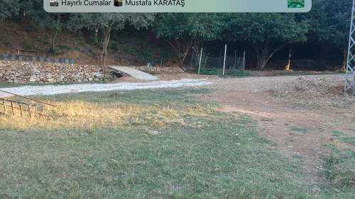 a field with a river and a rock wall at PASHA APART~BOUTİQUE HOTEL/YALOVA in Yalova