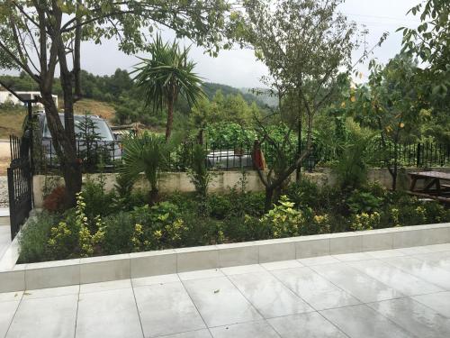 a garden with a table and trees and flowers at PASHA APART~BOUTİQUE HOTEL/YALOVA in Yalova