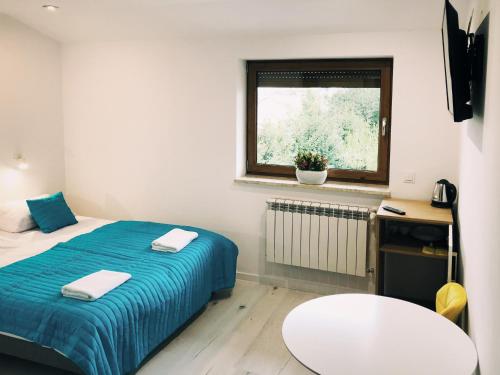 una piccola camera da letto con un letto e una finestra di Świerkowe Zacisze hotel a Firlej