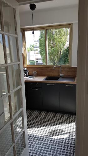une cuisine avec un évier et une fenêtre dans l'établissement COSY HELIOS, à Royan