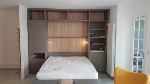 une petite chambre avec un lit et une chaise dans l'établissement COSY HELIOS, à Royan