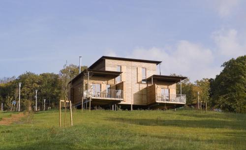 a house on top of a grassy field at Madame Vacances Les Cottages De Valjoly in Eppe-Sauvage