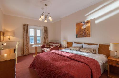 a bedroom with a large bed and a living room at Lutwidge Arms in Holmrook