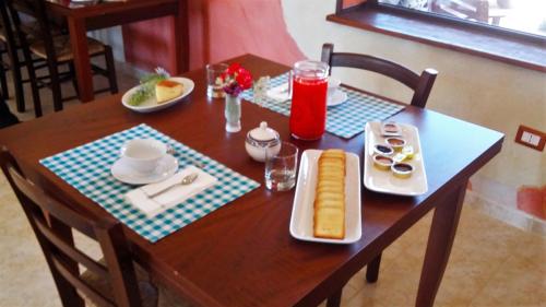 un tavolo in legno con un piatto di cibo sopra di Agriturismo Sogno Latino a Iglesias