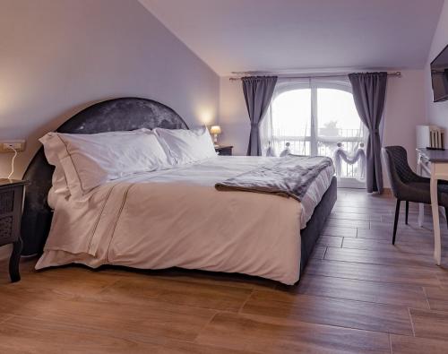a bedroom with a bed and a desk and a window at Le Mongolfiere in Mondovì