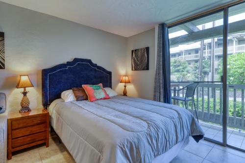1 dormitorio con 1 cama grande y balcón en Kona Bali Kai #165, en Kailua-Kona