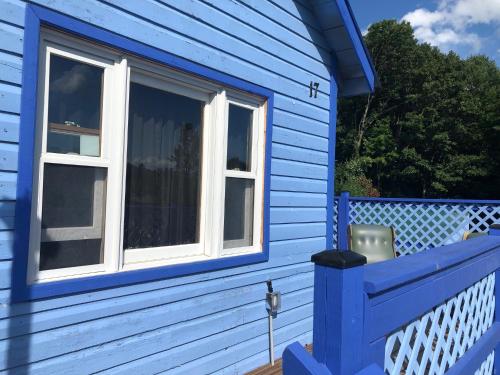 a blue house with a window on a porch at Hillside Motel in Lake George