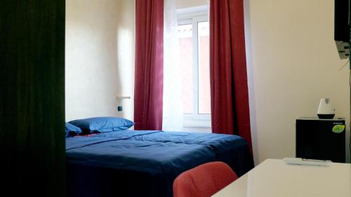 陶爾米納的住宿－National Gallery Taormina B&B，一间卧室设有蓝色的床和窗户。