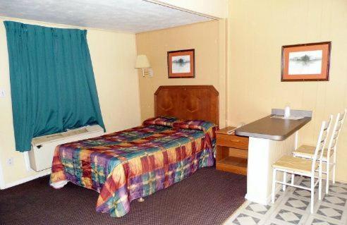 Habitación de hotel con cama y escritorio en Interstate Motel, en Wills Point